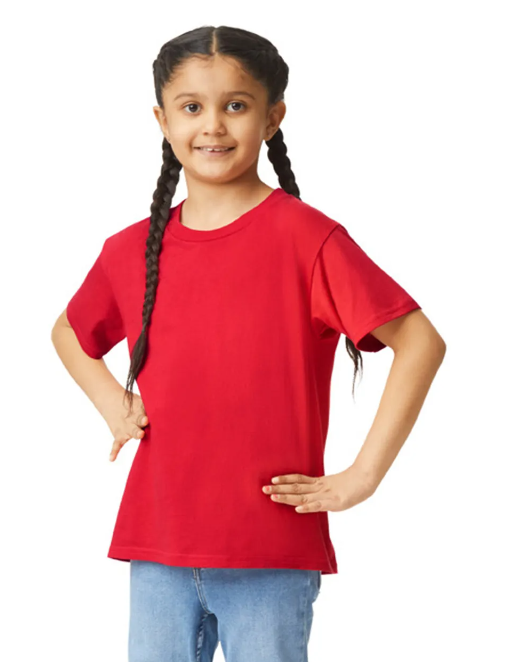 Young girl wearing a red t-shirt and blue jeans on a white background
