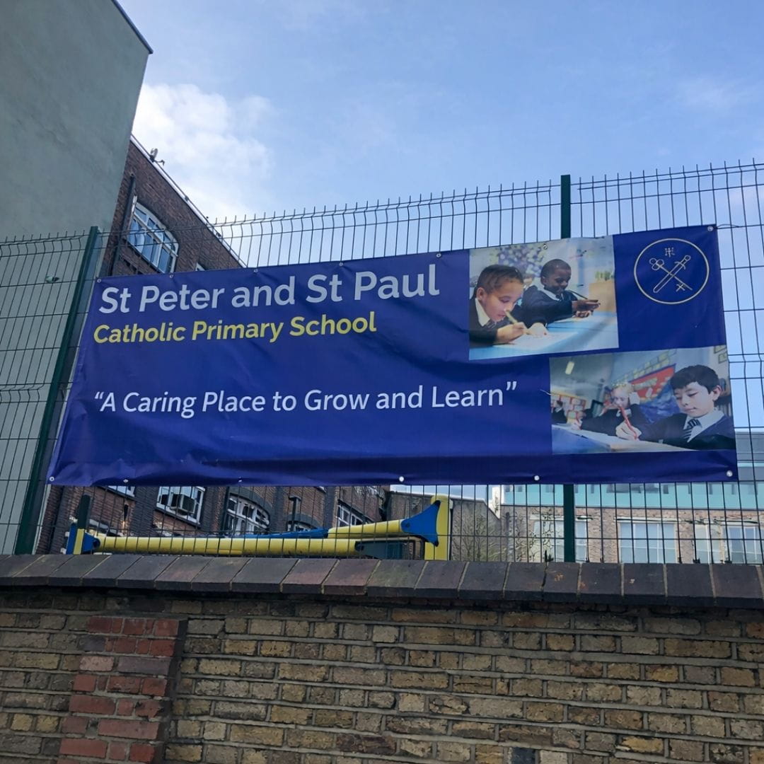 Banner for St Peter and St Paul Catholic Primary School on a school building.