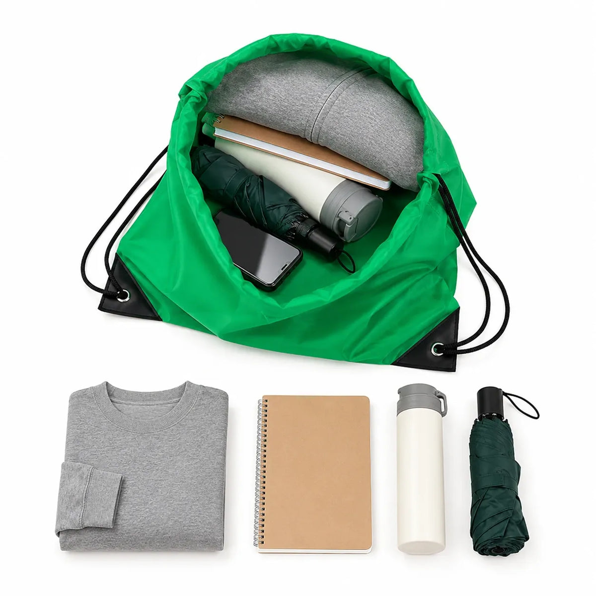 Green drawstring backpack opened showing large capacity with clothing, notebook, water bottle, and umbrella inside